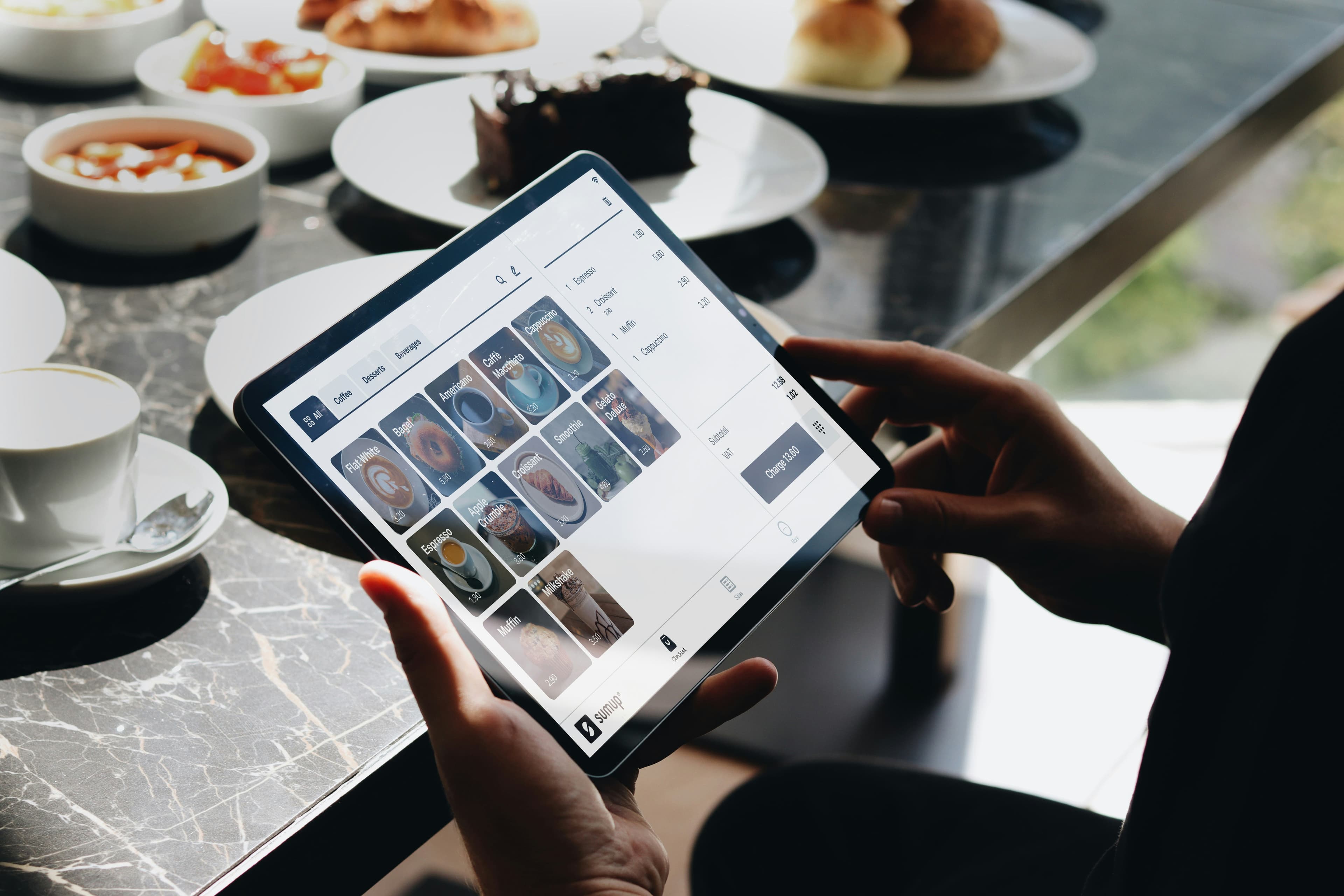 Customer browsing menu on tablet at restaurant